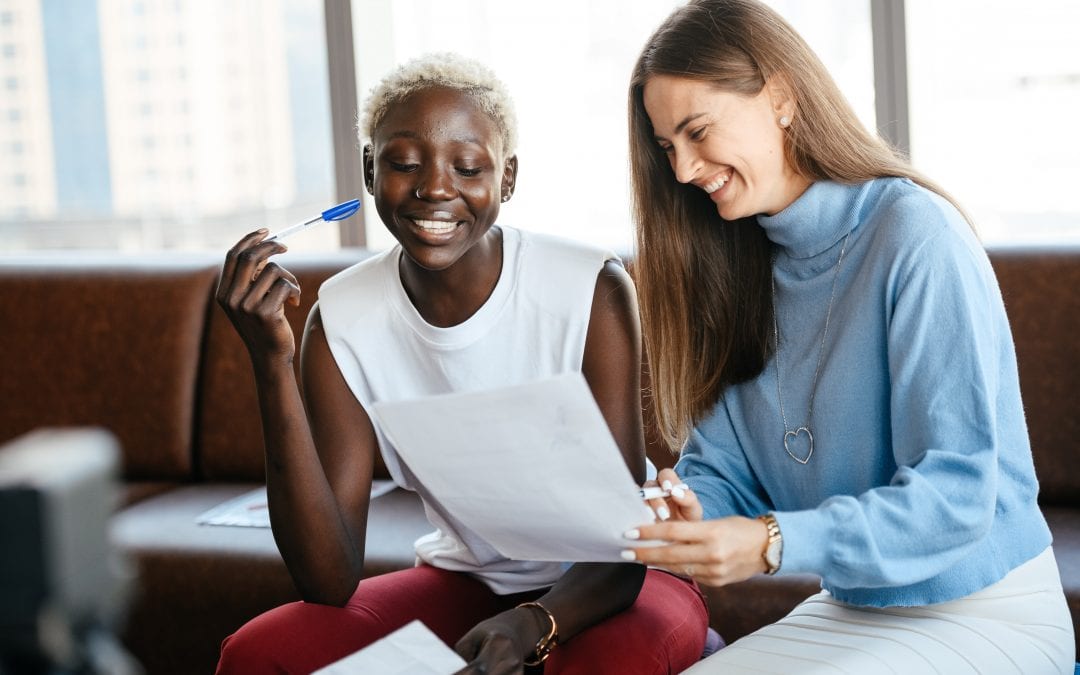 Cheerful multiethnic colleagues discussing contract in office