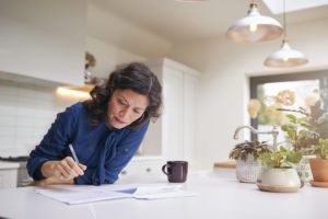 Mature Woman Reviewing And Signing Life Insurance